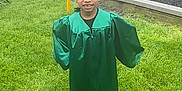 Jaquale joined the competition — help win amazing prizes! child, graduate, green_gown, graduation_cap, grass, playground, balloons, gift_bag, smile, outdoor, person, celebration, park, black_hair, shoe, fence, tree, toy_slide, daylight, happy