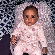 Ayla a rejoint le concours — aidez-le/la à gagner de superbes lots ! baby, infant, child, onesie, blanket, pillow, bed, patterned_bedspread, pink_clothing, heart_pattern, big_eyes, staring, sitting, lying_down, chubby_cheeks, hand, foot, portrait, indoor, cozy