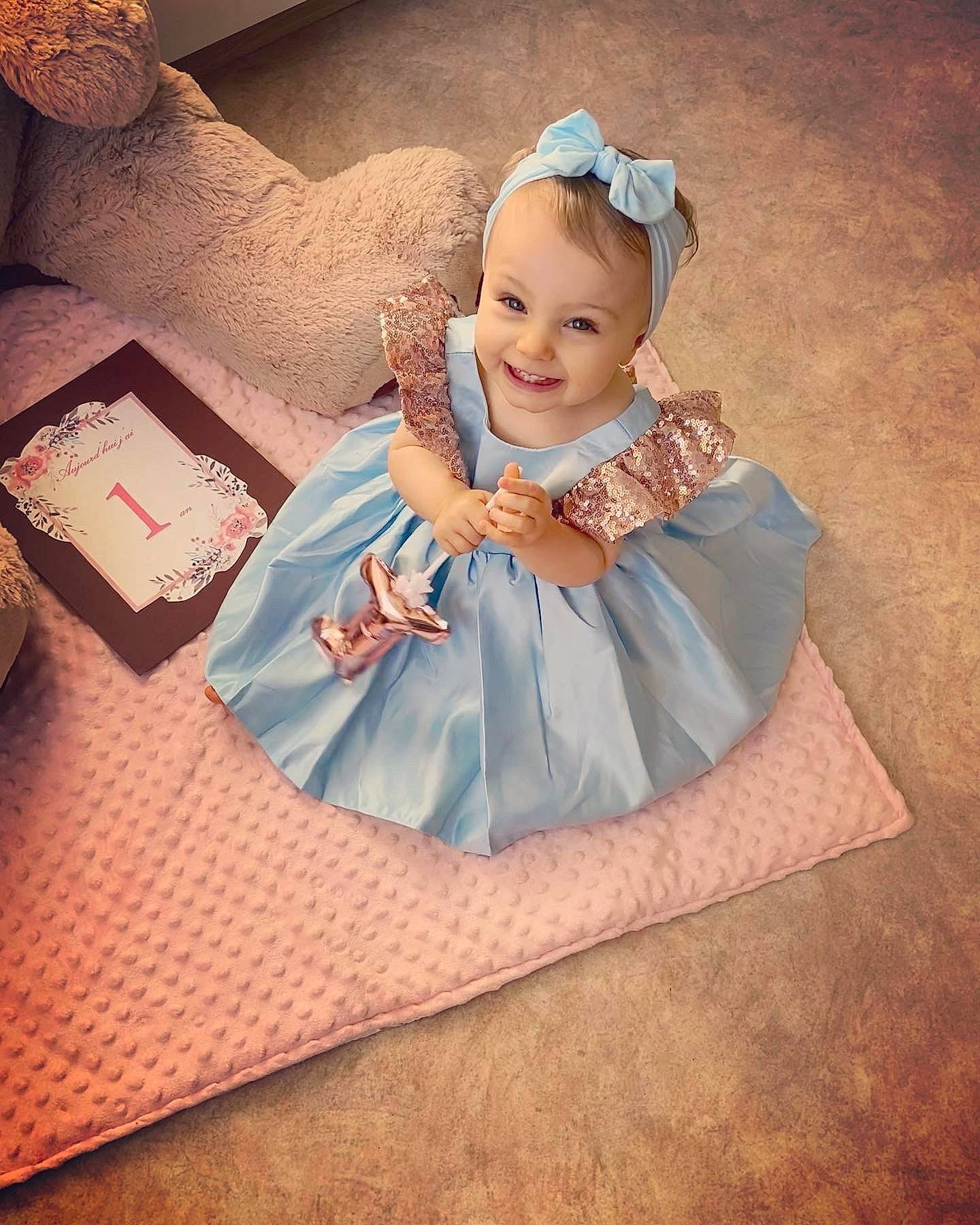 Tessa participe au concours pour gagner de l'argent avec cette photo : baby, baby_products, baby_toddler_clothing, child, cloud, comfort, dress, fashion_accessory, flash_photography, flooring, fun, happy, headband, headpiece, jewellery, joy, linens, person, sitting, sleeve