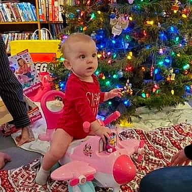 Jazmine is registered to the contest to win money with this photo: baby_toddler_clothing, baby_toys, bookcase, child, christmas, christmas_decoration, christmas_eve, christmas_ornament, christmas_tree, event, holiday, holiday_ornament, human, human_body, interior_design, ornament, person, shelf, shelving, toddler