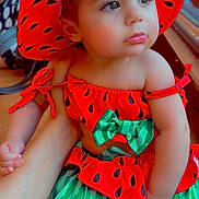 Sally joined the competition — help win amazing prizes! baby, bright_colors, child, clothing, cute, expression, face, fashion, hand, hat, indoor, looking_away, person, portrait, red_hat, sitting, skin, toddler, watermelon_outfit, young_child