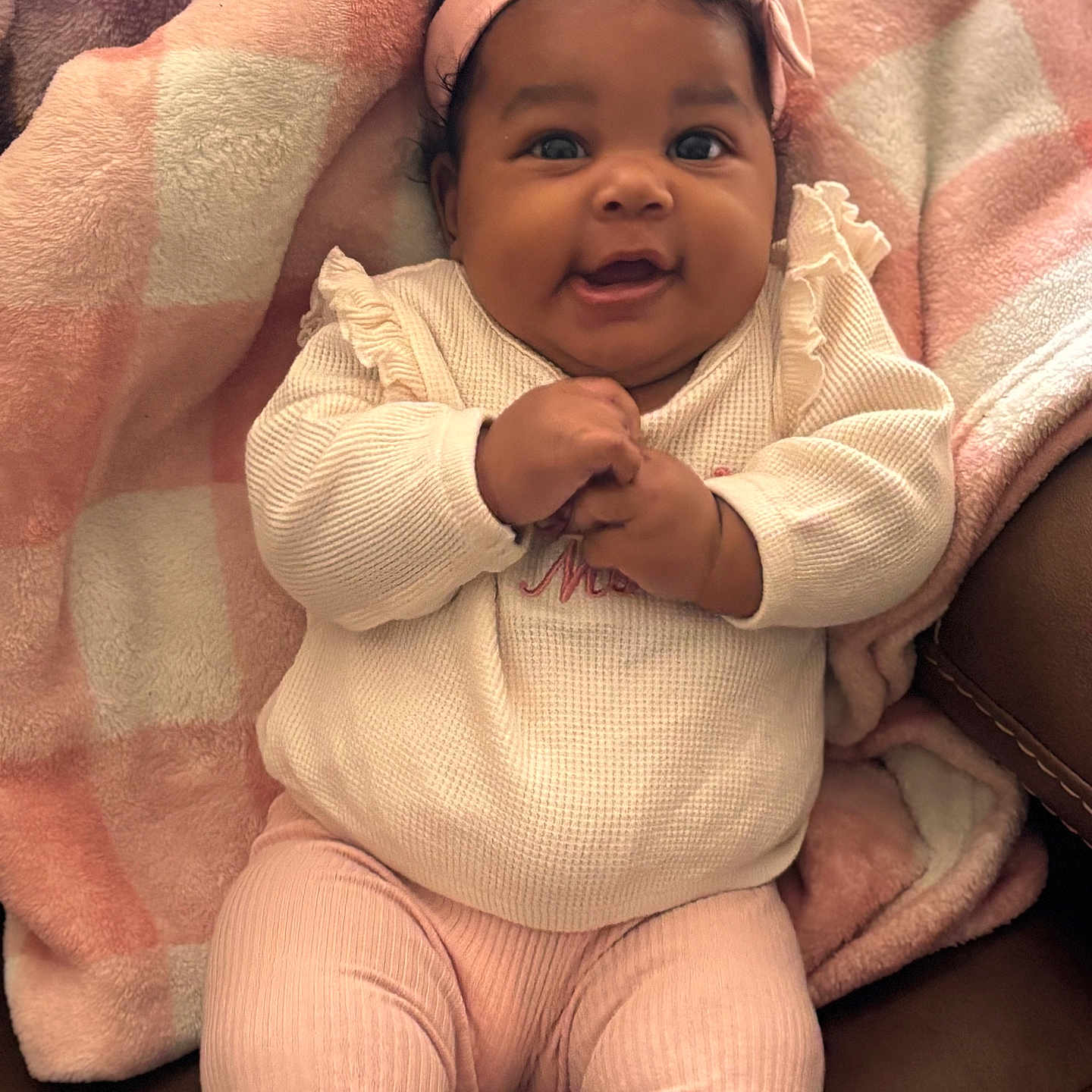 Mikiya is registered to the contest to win money with this photo: baby, blanket, child, comfortable, cozy, cute, expression, fashion, hands_clasped, happy, headband, indoors, infant, pink_clothing, portrait, sitting, smiling, soft_texture, warm, young