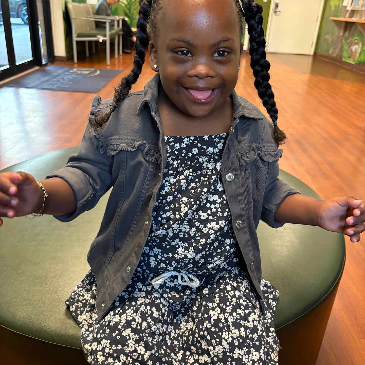 Iyumi is registered to the contest to win money with this photo: bench, braids, candid, child, door, dress, earrings, girl, happy, indoor, jacket, mural, person, pigtails, playful, portrait, sitting, smile, waiting_room, wood_floor