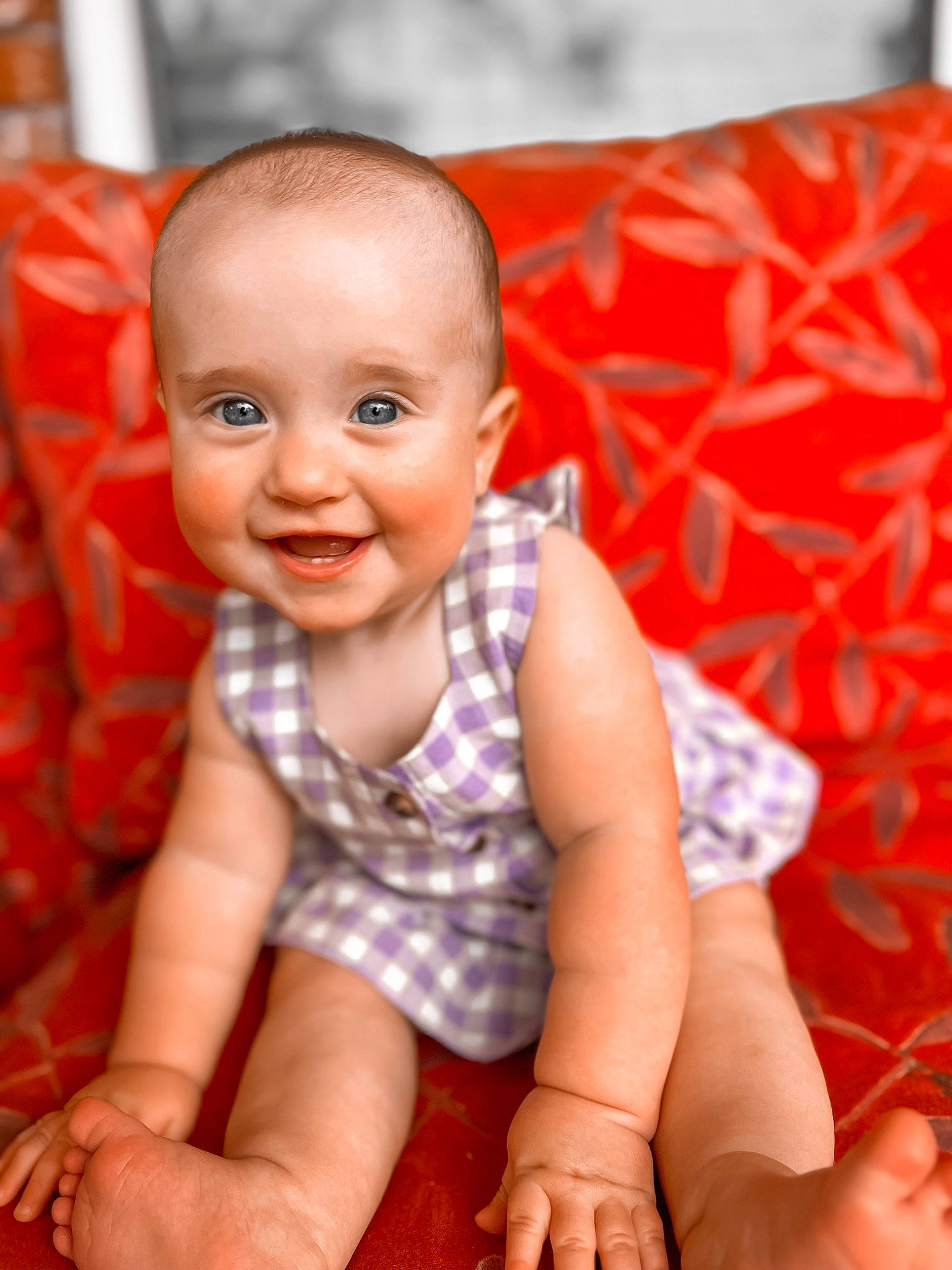 Evelyn is registered to the contest to win money with this photo: arm, baby, baby_toddler_clothing, cheek, chin, finger, flash_photography, floor, flooring, hand, happy, joy, lip, mouth, nose, orange, person, skin, sleeve, smile