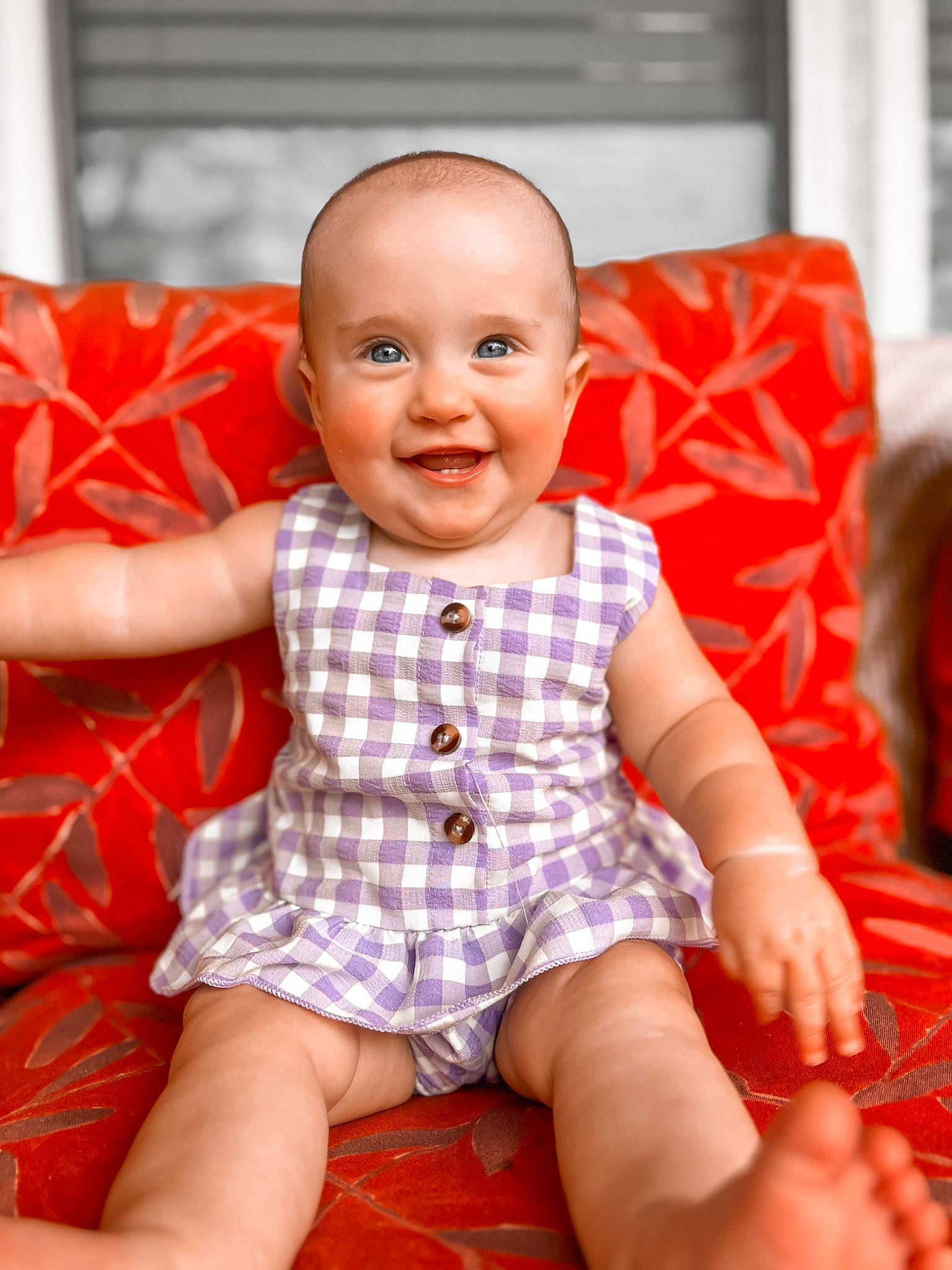Evelyn is registered to the contest to win money with this photo: baby, baby_toddler_clothing, cheek, child, finger, flooring, fun, happy, human_leg, joy, orange, pattern, person, red, shorts, sitting, skin, sleeve, smile, thigh