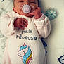 baby, blanket, butterfly, child, cozy, cute, digital_heart, face, head, infant, lying_down, newborn, pacifier, patterned_blanket, peaceful, pink_clothing, sleeping, small_hands, soft_texture, unicorn_patch