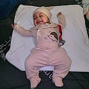 Xavier joined the competition — help win amazing prizes! baby, infant, smiling, lying_down, cute, clothing, hat, towel, bed, blanket, pattern, happy, face, person, child, indoor, soft, comfort, relaxed, pajamas