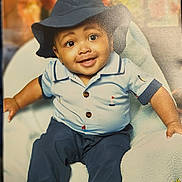 Xavier is registered to the contest to win money with this photo: baby, background, blue_clothing, chair, child, cozy, cute, face, happy, hat, indoor, infant, nautical_theme, pants, person, photography, portrait, shirt, sitting, smile