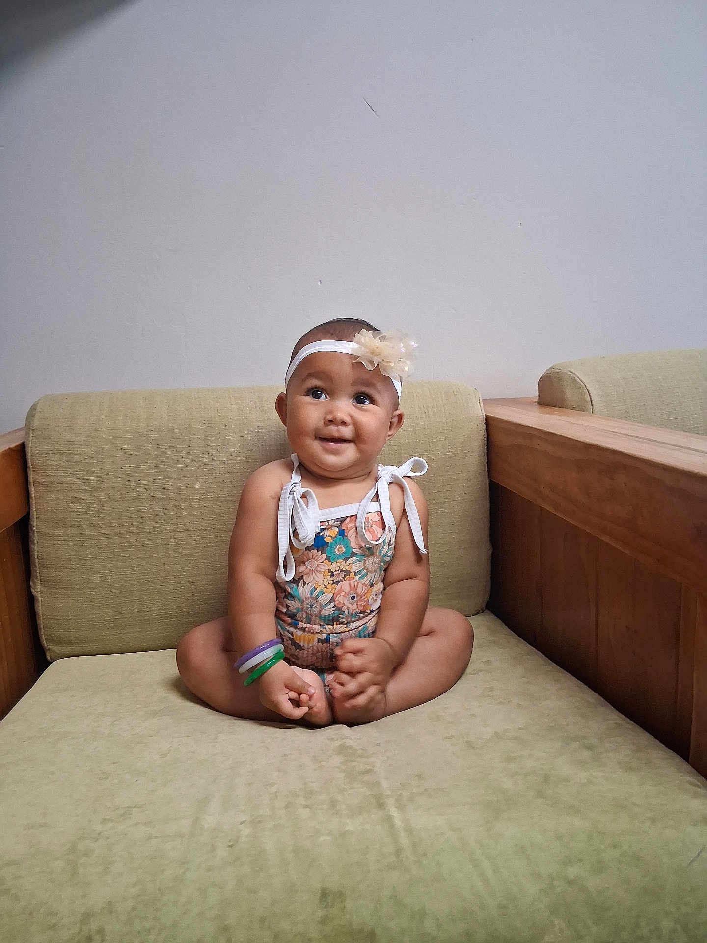 Kaimani joined the competition — help win amazing prizes! baby, child, smile, flower_headband, bracelets, sofa, furniture, cross_legged, indoor, cute, happy, person, portrait, floral_outfit, headband, infant, seated, skin, arm, foot