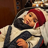 Angelo participe au concours pour gagner de l'argent avec cette photo : child, toddler, baby, beanie, winter_coat, scarf, car_seat, stroller, big_eyes, smile, hand, mittens, warm_clothing, indoor, cafe, wood_paneling, bokeh, portrait, cozy, seatbelt