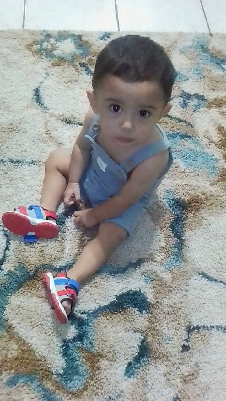 Marco is registered to the contest to win money with this photo: azure, baby, baby_toddler_clothing, child, electric_blue, flooring, foot, fun, grass, happy, human_leg, leg, leisure, people_in_nature, person, play, sand, sitting, soil, toddler