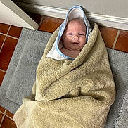 Hudson joined the competition — help win amazing prizes! baby, towel, hood, floor, tile_floor, mat, indoor, child, wrapped, blanket, infant, cute, smile, face, head, skin, person, cozy, bath, young