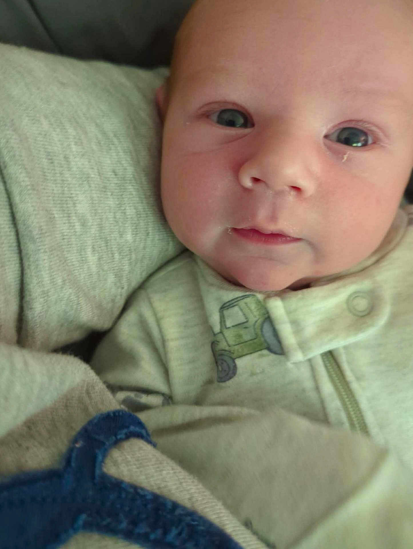 Callaway is registered to the contest to win money with this photo: baby, infant, face, eyes, clothing, blanket, soft_texture, closeup, cute, newborn, child, portrait, sleepwear, cozy, expression, skin, head, young, indoors, resting