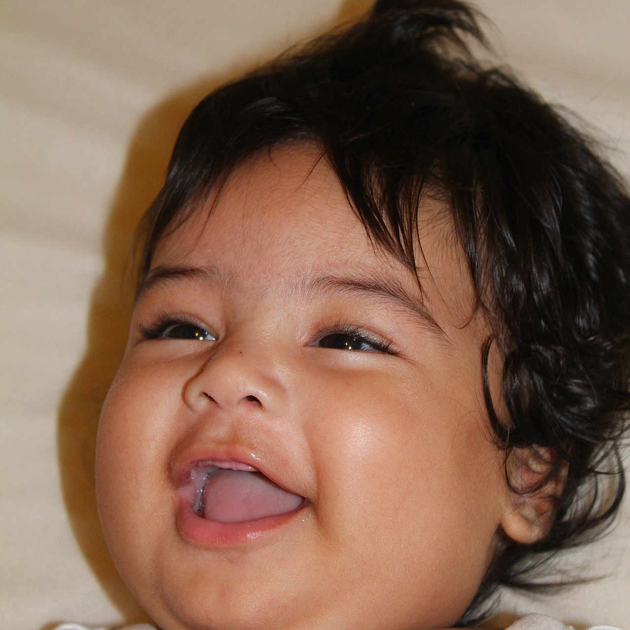 Matahi a rejoint le concours — aidez-le/la à gagner de superbes lots ! baby, bed, cheek, child, close_up, cute, dark_hair, drool, eyes, face, happy, infant, laughing, lying_down, portrait, skin, smiling, teeth, tongue, white_shirt