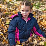 child, girl, autumn, leaves, jacket, outdoor, nature, fall, playful, seasonal, portrait, young, curly_hair, park, cool_weather, casual_clothing, daylight, face, expression, fun