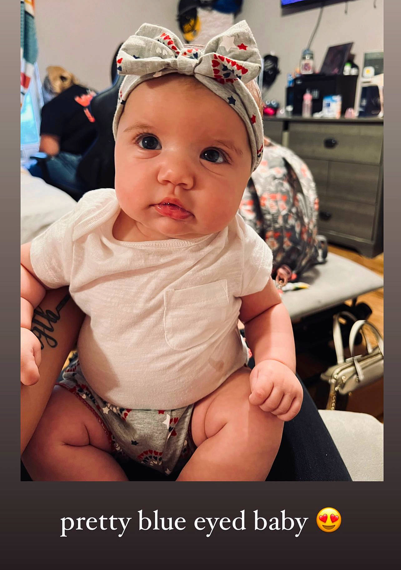 Alaia is registered to the contest to win money with this photo: abdomen, baby, baby_toddler_clothing, cap, cheek, chest, child, event, face, fashion_accessory, fun, happy, headwear, human_leg, knee, person, photo_caption, room, sitting, television
