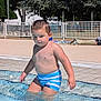 blue, boy, child, daytime, fence, leisure, nature, outdoor, person, playing, pool, recreation, summer, sunlight, swimming_trunks, trees, vacation, water, wet, young