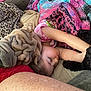 dog, child, sleeping, blanket, couch, plush, wrinkles, snout, nap, cozy, fur, leopard_print, colorful_blanket, arm, eyelashes, pillow, soft_texture, home_interior, pet, blanket_pattern