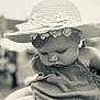 Evie is registered to the contest to win money with this photo: baby, baby_girl, black_and_white, child, close_up, clothing, cute, fabric, face, flower, hat, headwear, infant, outdoor, person, portrait, serene, soft_focus, timeless, young