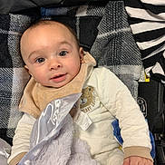 Ace is registered to the contest to win money with this photo: baby, infant, blanket, clothing, face, child, portrait, smile, hand, soft_texture, fabric, plaid, striped, cozy, cute, apparel, bedtime, comfort, toddler, indoor