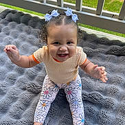 Mileigh joined the competition — help win amazing prizes! baby, blanket, child, clothing, curly_hair, cute, floral_pattern, grass, gray_blanket, hair_bows, happy, infant, leggings, outdoor, person, porch, railing, sitting, smiling, toddler