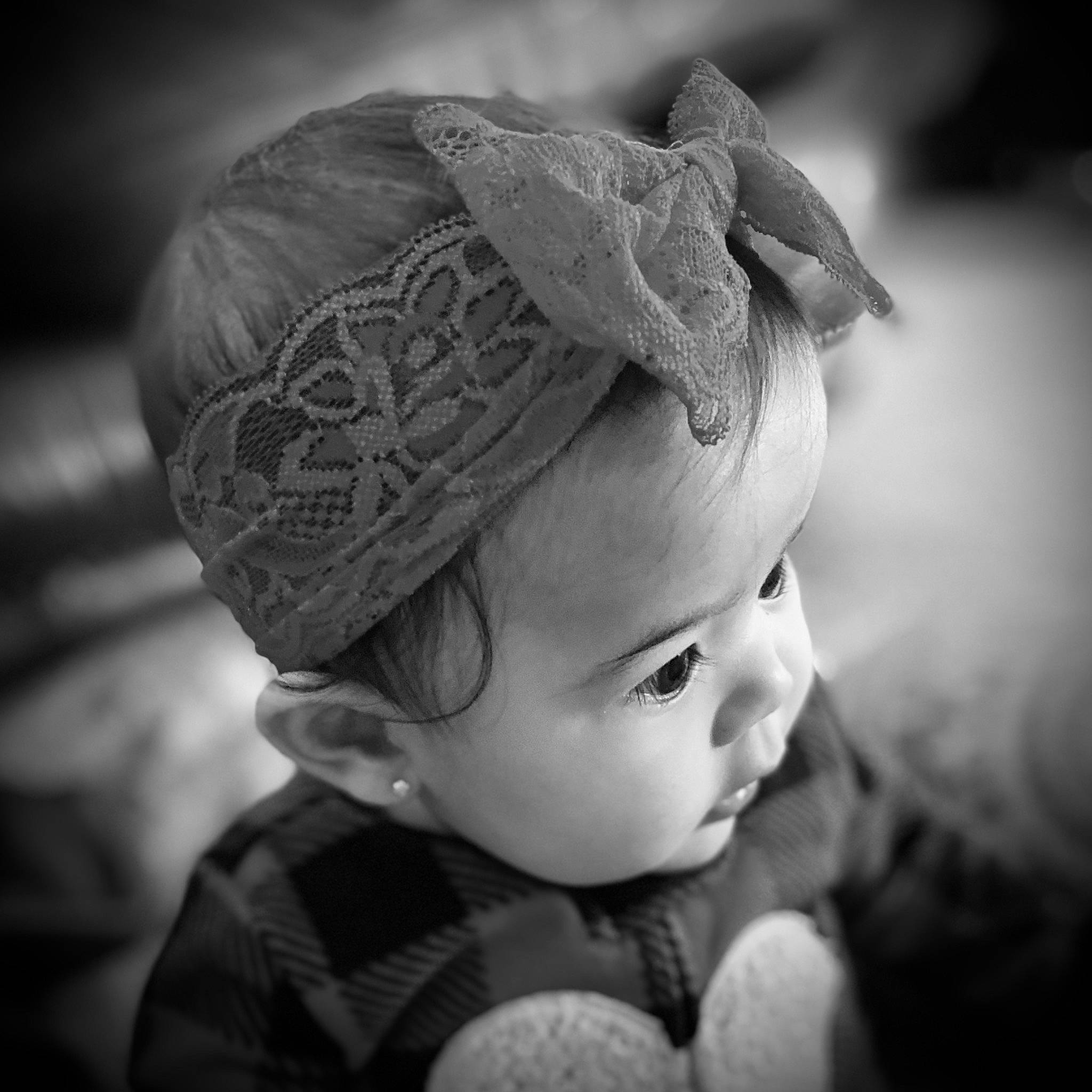 Emmaline is registered to the contest to win money with this photo: baby, baby_toddler_clothing, cap, cheek, child, close_up, eye, eyelash, fashion_accessory, flash_photography, hair_accessory, happy, headgear, iris, lip, monochrome, monochrome_photography, person, skin, style