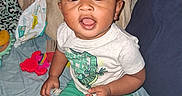 Bishop joined the competition — help win amazing prizes! baby, child, infant, sitting, bed, bedroom, portrait, wide_eyes, open_mouth, curly_hair, smiling, toddler, green_shorts, white_shirt, socks, toy, baby_wipes, bedding, indoor, flash_photography