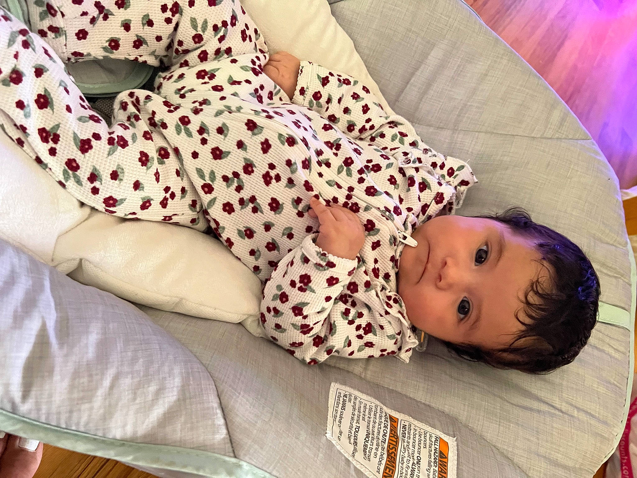Julie is registered to the contest to win money with this photo: baby, baby_products, baby_toddler_clothing, bedding, carmine, child, comfort, facial_expression, flooring, human_leg, linens, magenta, nightwear, pattern, person, room, skin, sleeve, textile, thigh