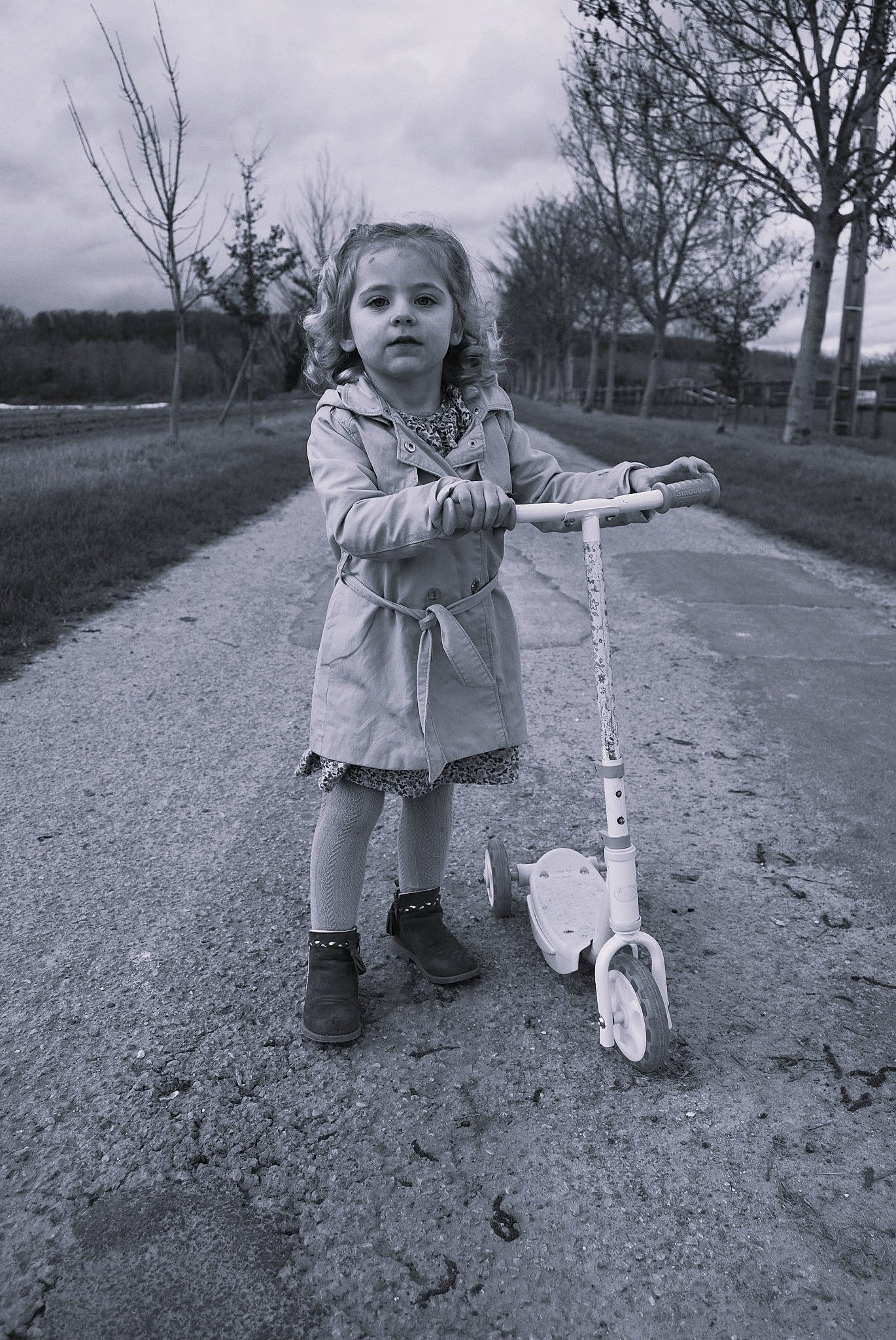 Jade a rejoint le concours — aidez-le/la à gagner de superbes lots ! asphalt, black, black_and_white, child, cloud, flash_photography, fun, grass, monochrome, monochrome_photography, people_in_nature, person, plant, sky, sneakers, standing, style, tire, toddler, tree