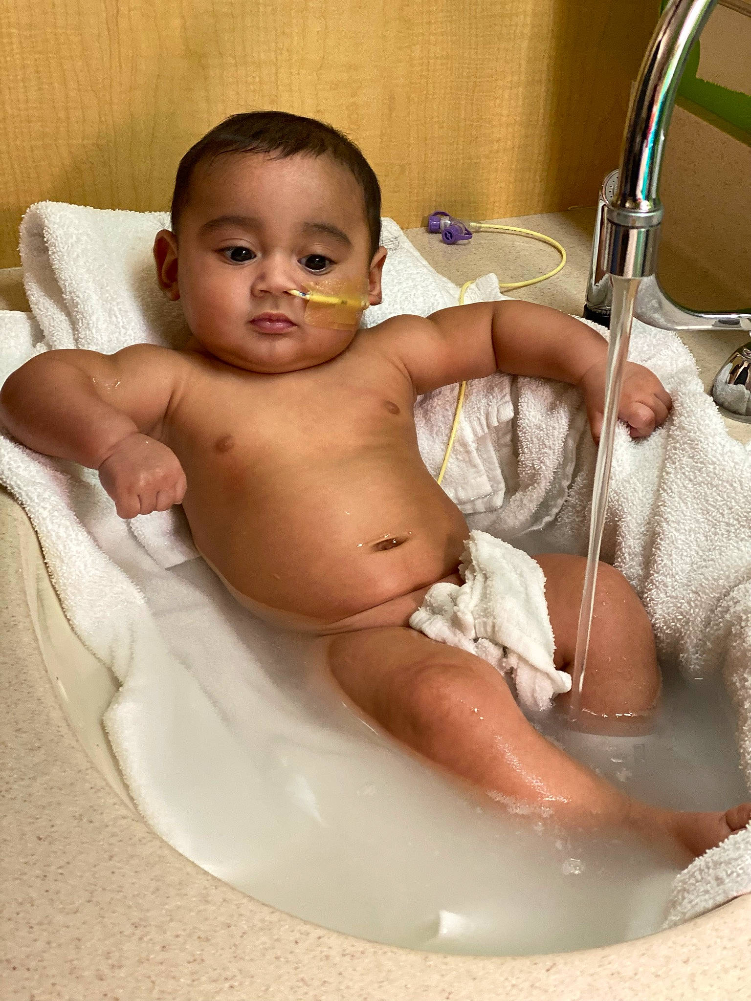 Dani is registered to the contest to win money with this photo: arm, baby, baby_bathing, bathroom, cheek, chest, eye, eyebrow, face, finger, fluid, hand, head, human_body, iris, mouth, person, skin, stomach, toddler