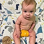 baby, infant, child, sitting, yellow_diaper, dinosaur_blanket, milestone_sign, eight_months, cute, chubby, skin, hand, foot, face, eyes, smile, indoors, blanket, wooden_sign, portrait