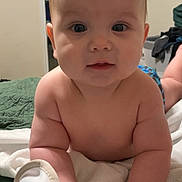 Jensen joined the competition — help win amazing prizes! baby, infant, child, face, hands, bed, blanket, quilt, indoor, room, ceiling_fan, american_flag, skin, curious, looking, lying_down, portrait, closeup, soft_lighting, cozy