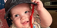 Jensen is registered to the contest to win money with this photo: baby, child, cap, hat, infant, smiling, face, hand, clothing, seat, quilt, indoor, cute, happy, person, closeup, portrait, casual, holding, cheeks