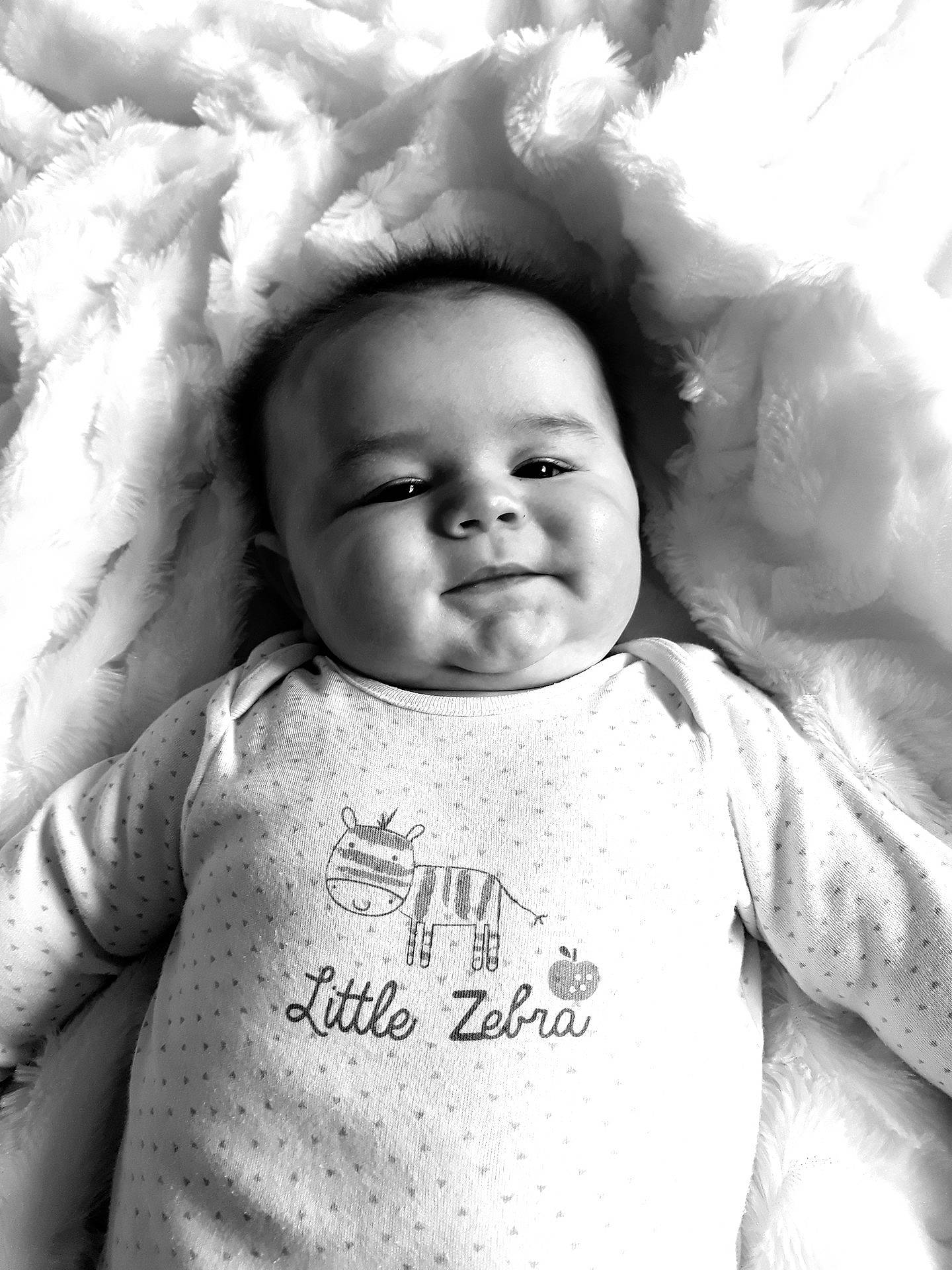 Alfie is registered to the contest to win money with this photo: black, black_and_white, cheek, child, emotion, eye, face, facial_expression, forehead, girl, head, human, infant, monochrome, monochrome_photography, person, photograph, photography, smile, white