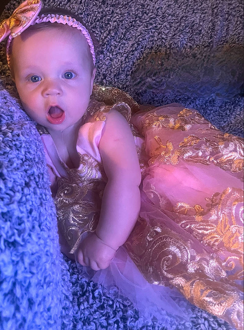 Gwendolyn is registered to the contest to win money with this photo: baby, baby_toddler_clothing, blue, child, electric_blue, embellishment, fashion_accessory, flash_photography, fun, happy, headpiece, iris, magenta, pattern, person, petal, pink, purple, surprise, textile