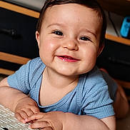 Antoine a rejoint le concours — aidez-le/la à gagner de superbes lots ! baby, child, smiling, happy, face, blue_clothing, indoor, portrait, cute, infant, hands, skin, table, closeup, young_child, person, cheerful, toddler, baby_face, expression