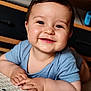 baby, child, smiling, happy, face, blue_clothing, indoor, portrait, cute, infant, hands, skin, table, closeup, young_child, person, cheerful, toddler, baby_face, expression