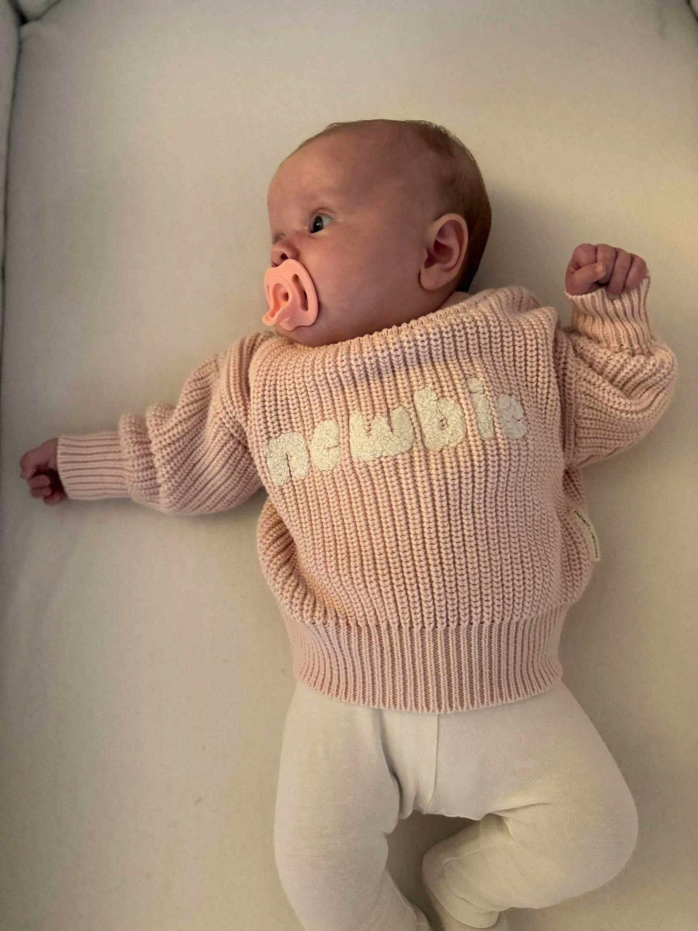 Maddie joined the competition — help win amazing prizes! baby, infant, pacifier, sweater, knitted, pink, white_pants, lying_down, soft_surface, newborn, cute, child, sleepwear, cozy, indoors, portrait, small_hands, small_feet, face, head
