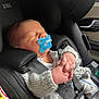 baby, pacifier, car_seat, child, sleeping, infant, knitted_sweater, seatbelt, hands, clothing, car_interior, peaceful, cute, newborn, face, person, transportation, safety, resting, comfort