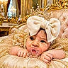 baby, child, pacifier, crown, bow, golden, luxury, plush, cushion, royalty, dress, sparkle, chandelier, indoor, portrait, cute, infant, decor, face, hands