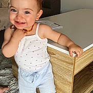 Lyana participe au concours pour gagner de l'argent avec cette photo : barefoot, carpet, child, cute, face, floor, furniture, happy, home, indoor, living_room, necklace, person, shorts, skin, smiling, standing, tank_top, toddler, wooden_table