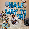 Ja'Majesty joined the competition — help win amazing prizes! baby, balloons, birthday, blue_balloon_letters, cake, celebration, chair, child, cute_outfit, decorations, donut_balloon, festive, fluffy_carpet, indoor, ladder_decoration, milestone_board, portrait, smiling, teddy_bear_cake, white_chair