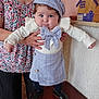 Candice a rejoint le concours — aidez-le/la à gagner de superbes lots ! baby, child, person, blue_eyes, plaid, hat, bow, skirt, white_top, standing, adult_hands, floral_shirt, indoor, wooden_surface, decor, birdhouse, cute, chubby, footwear, helping