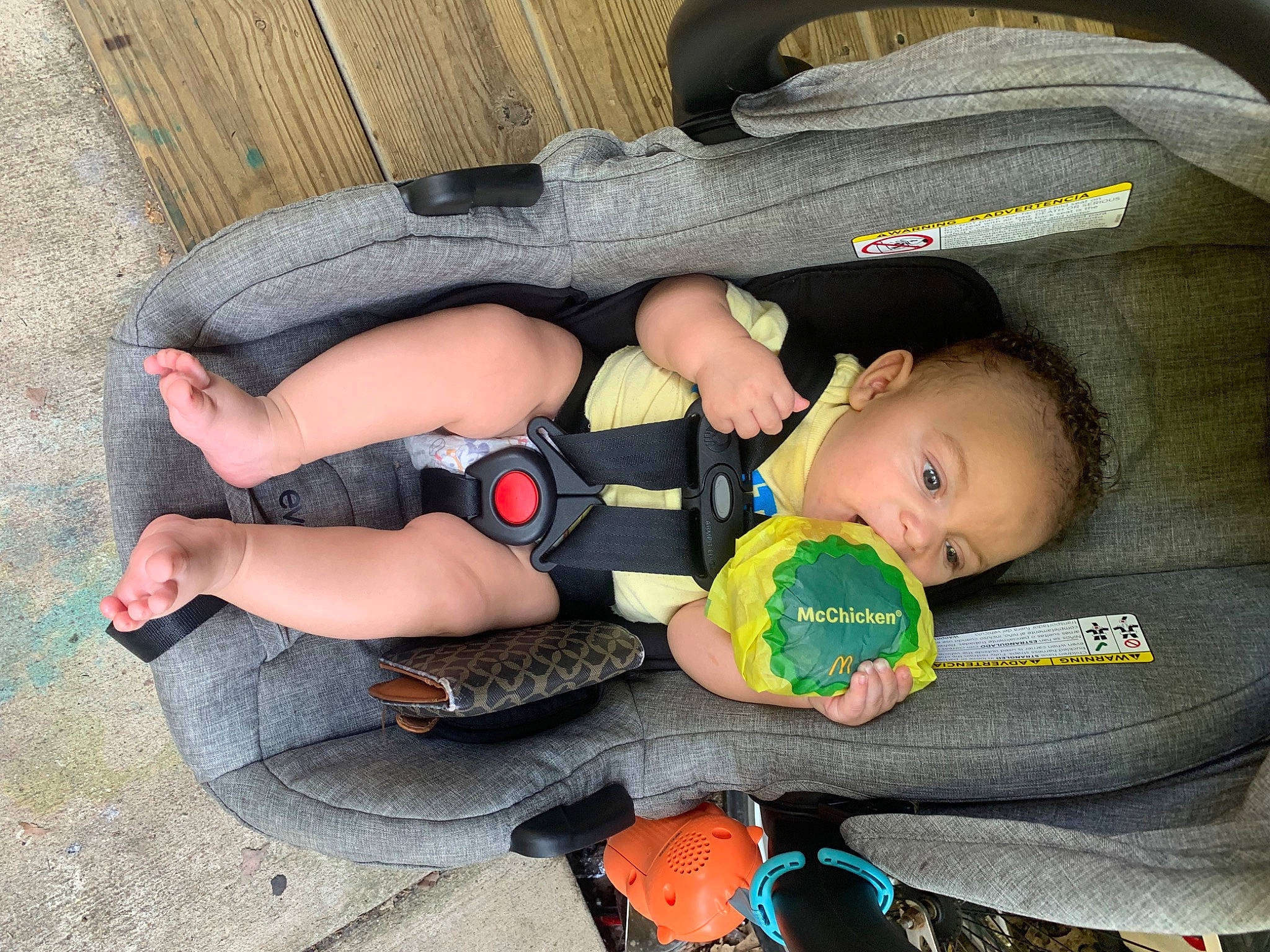 Carter is registered to the contest to win money with this photo: baby, baby_carriage, baby_products, baby_toddler_clothing, bag, car_seat, child, comfort, finger, foot, fun, grass, knee, lap, luggage_and_bags, person, personal_protective_equipment, sitting, sock, thigh