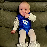 Aurora joined the competition — help win amazing prizes! apparel, baby, blue_outfit, child, clothing, couch, cute, face, footwear, frills, furniture, happy, indoor, infant, person, portrait, shoes, sitting, smiling, white_tights