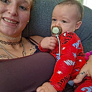 James joined the competition — help win amazing prizes! baby, infant, adult, parent, cuddling, smiling, pacifier, red_outfit, star_pattern, tattoos, portrait, indoor, couch, seated, family, caregiver, closeup, happy, home, photography