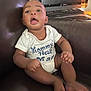 baby, child, infant, onesie, couch, leather, computer, monitor, keyboard, sitting, indoor, expression, mouth_open, hands, feet, face, young, casual, home, technology