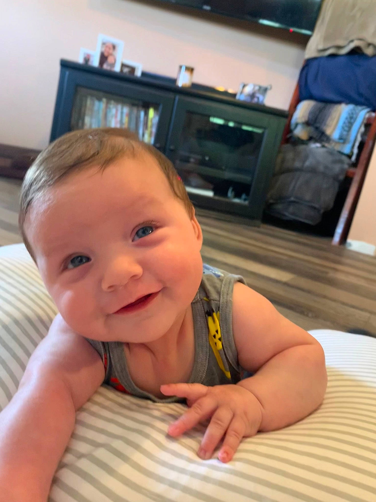 Benji is registered to the contest to win money with this photo: baby, baby_toddler_clothing, cheek, chest, finger, floor, flooring, fun, joint, joy, lip, nose, person, skin, smile, standing, table, television, thumb, toddler