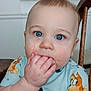 Jacob joined the competition — help win amazing prizes! baby, child, blue_eyes, hand_in_mouth, shirt, cartoon_print, chair, wooden_furniture, indoor, face, skin, cute, expression, table, paper_towels, household, furniture, person, portrait, closeup