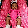 baby, infant, child, pink_clothing, headband, bow, polka_dot, cushion, seat, socks, cute, smiling, indoors, portrait, young_child, resting, comfort, fabric, person, cozy
